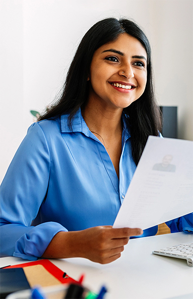 Woman smiling while holding an A4-sized paper